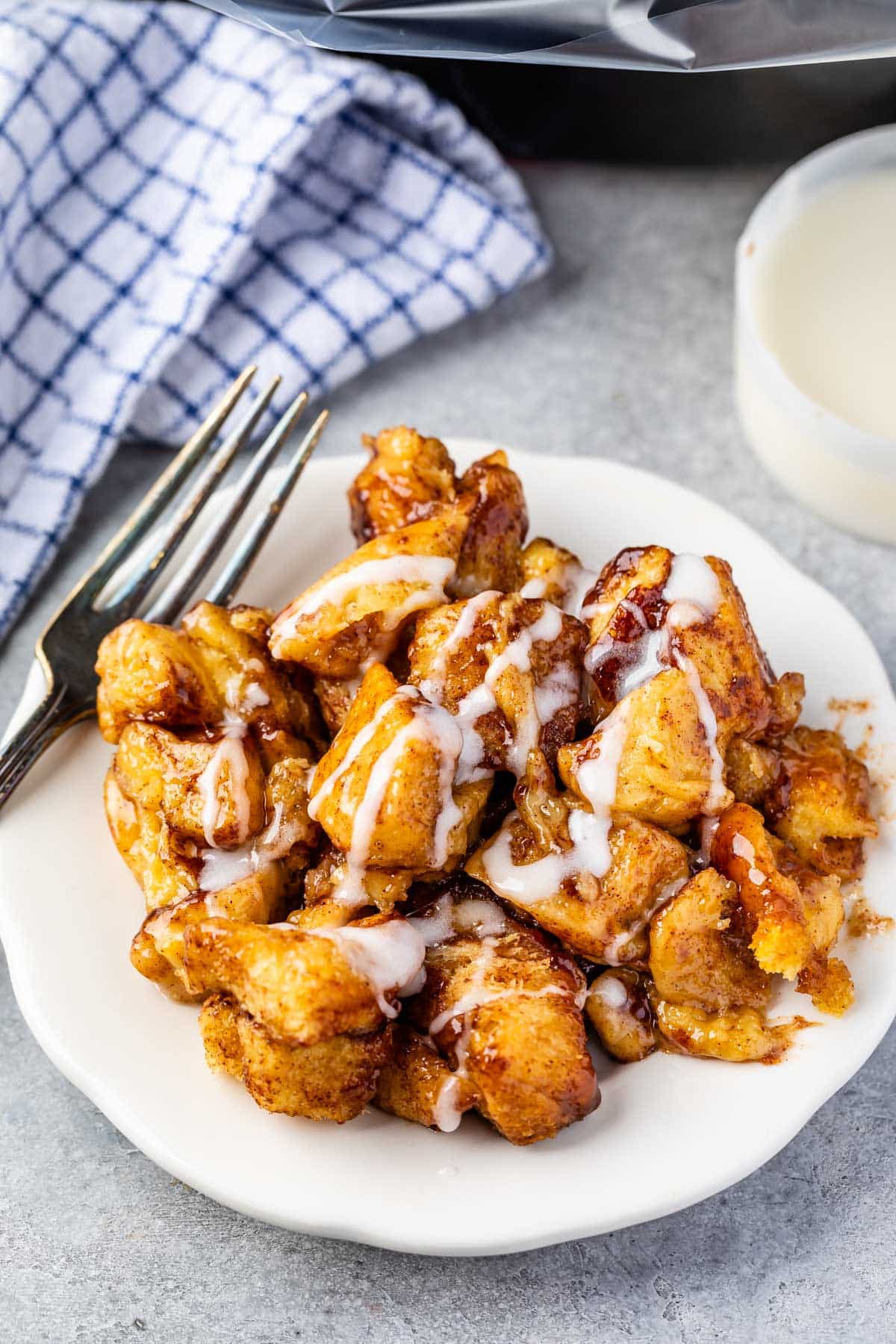 monkey bread covered in icing on a white plate