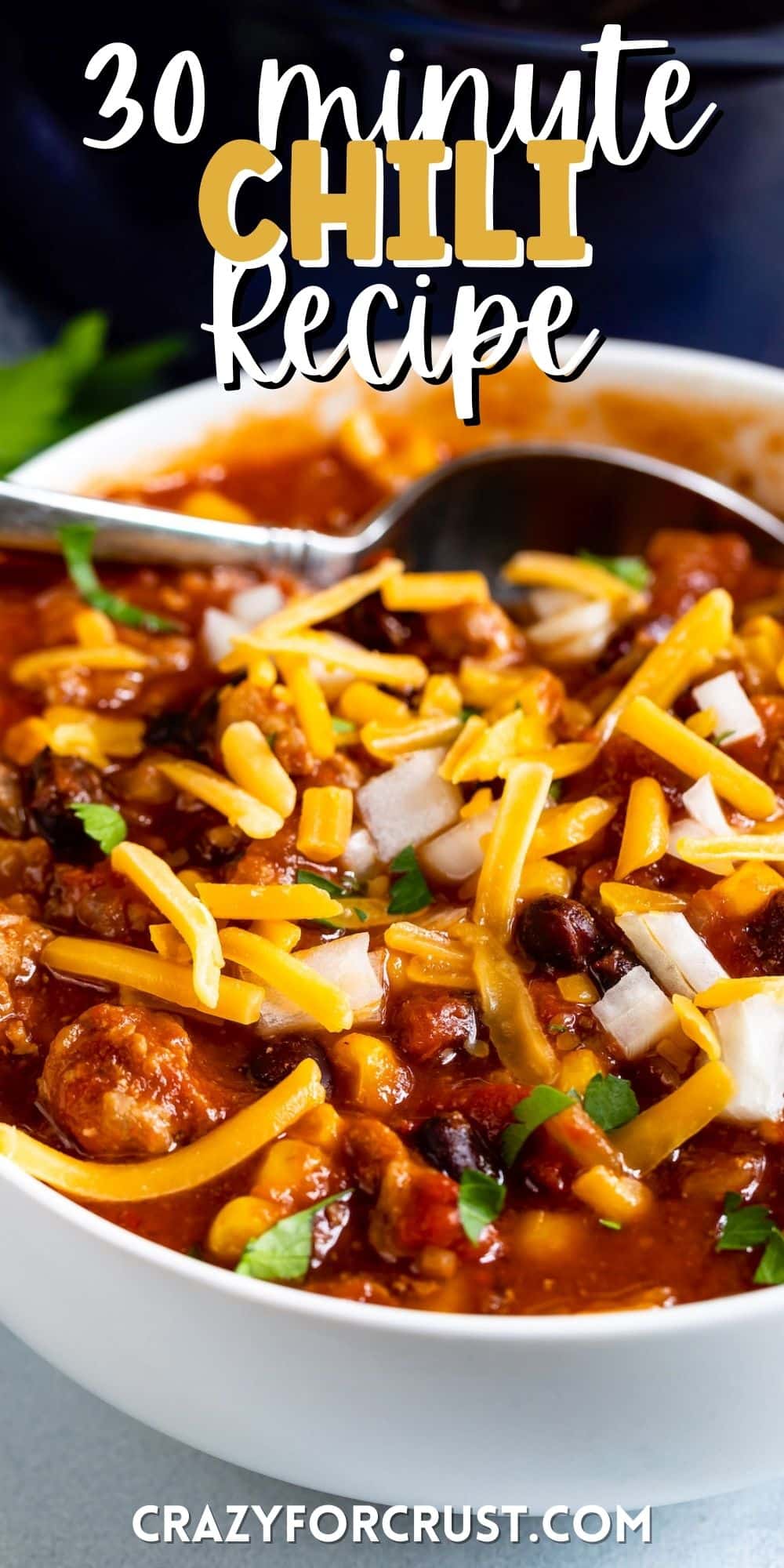 chili covered in cheese in a white bowl with words on top