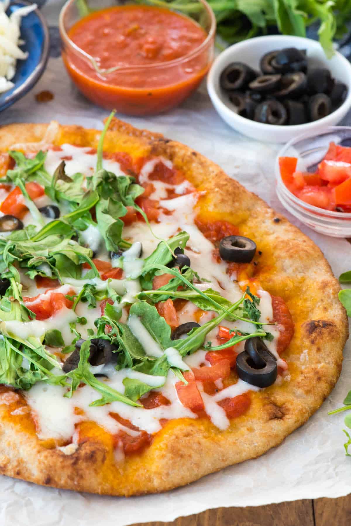 pizza with olives and arugula on top