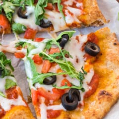 pizza with olives and arugula on top