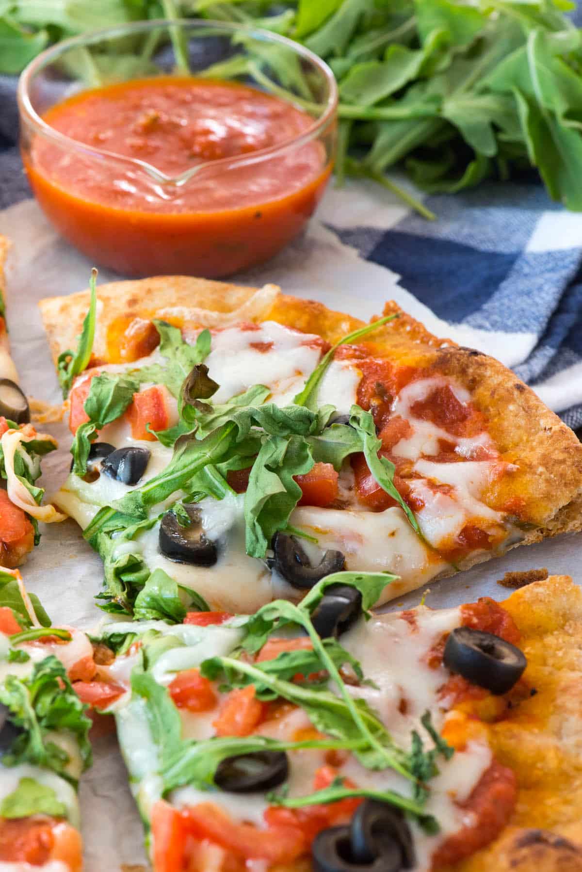 pizza with olives and arugula on top
