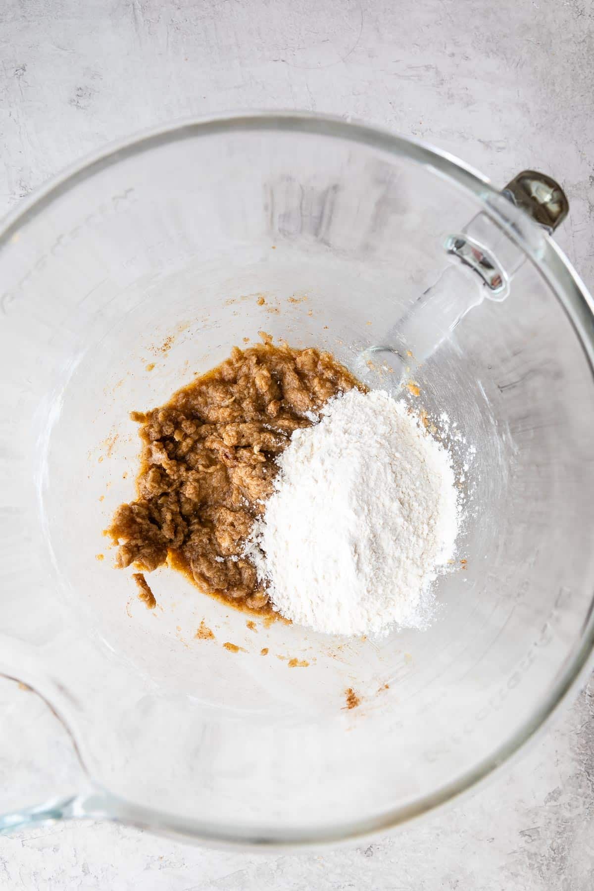 cookie dough with flour in clear bowl.