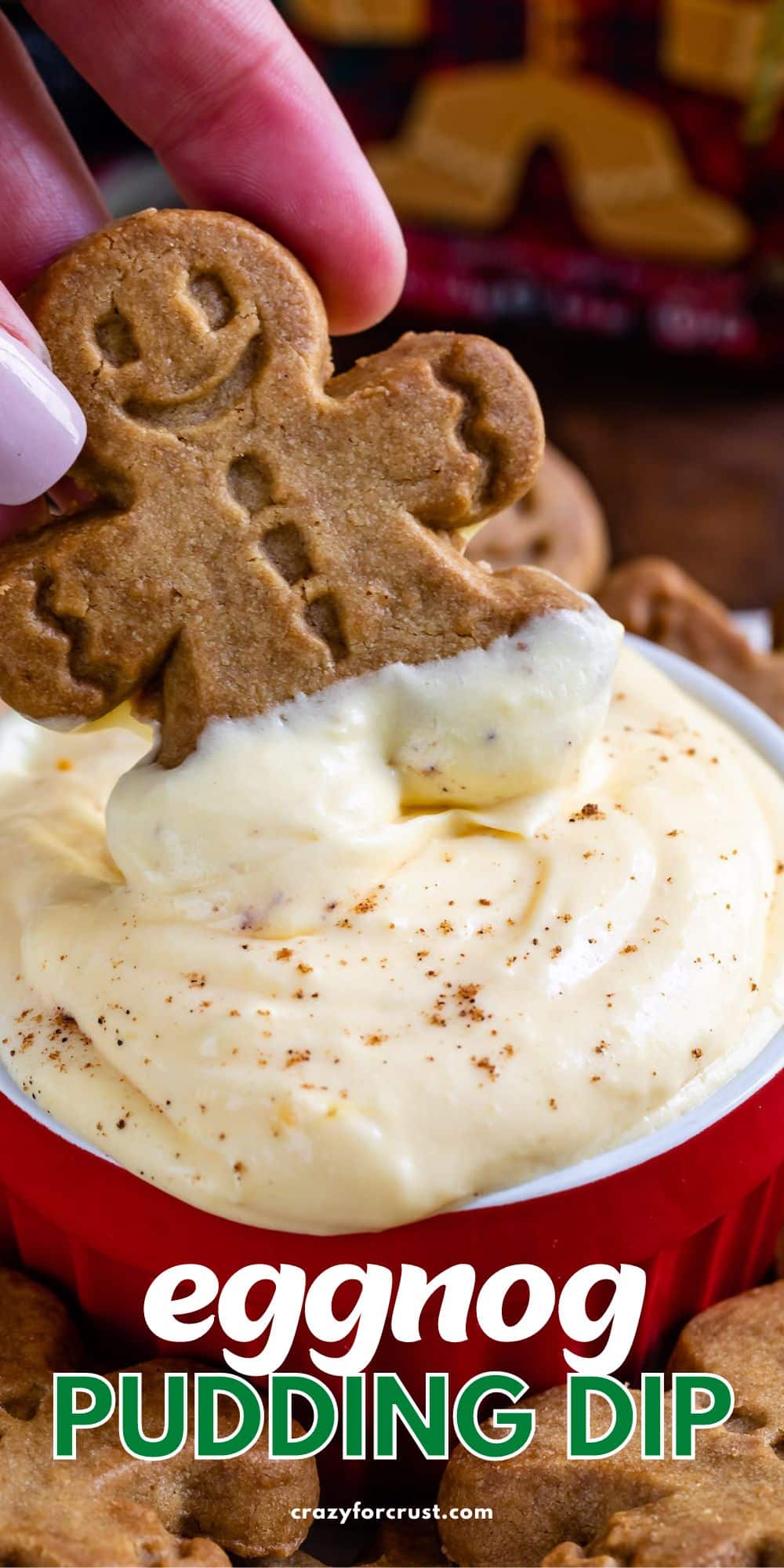 hand dipping cookie in eggnog pudding