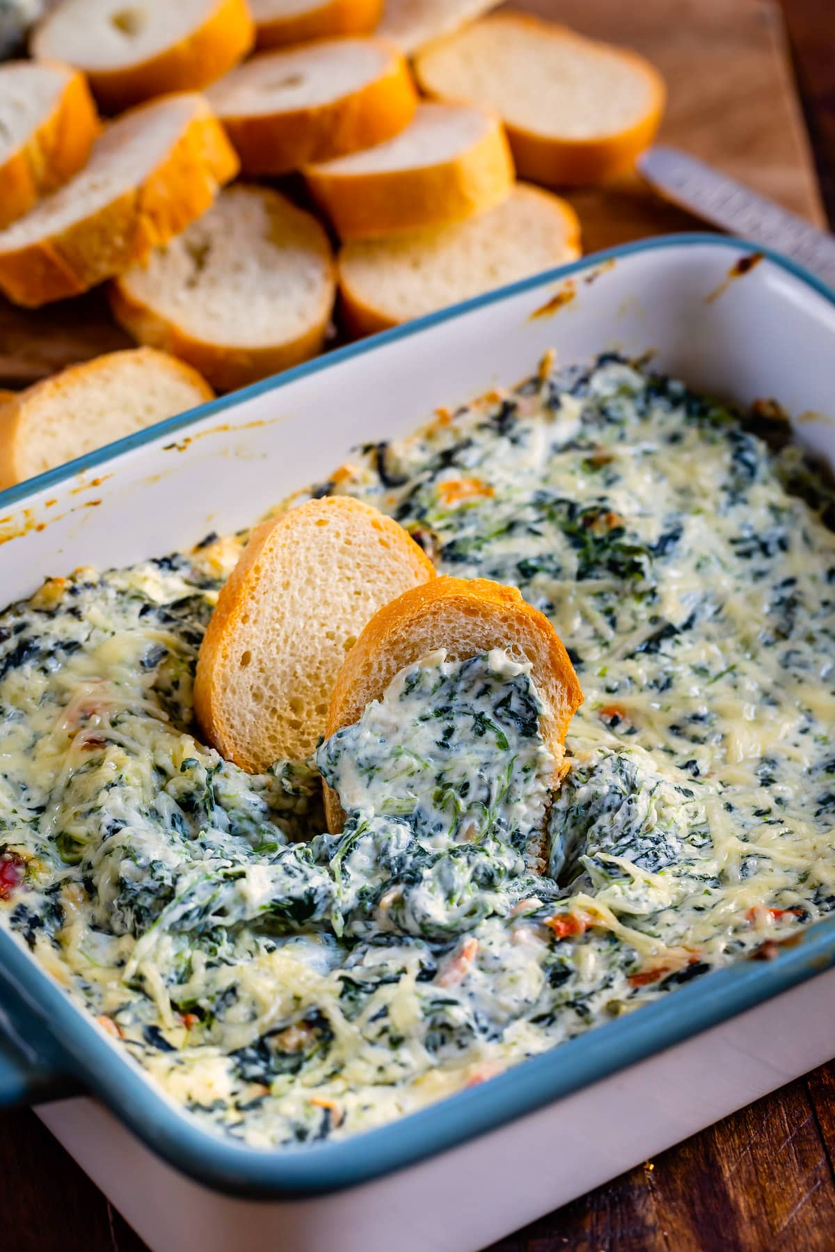 bread being dipped in the spinach dip