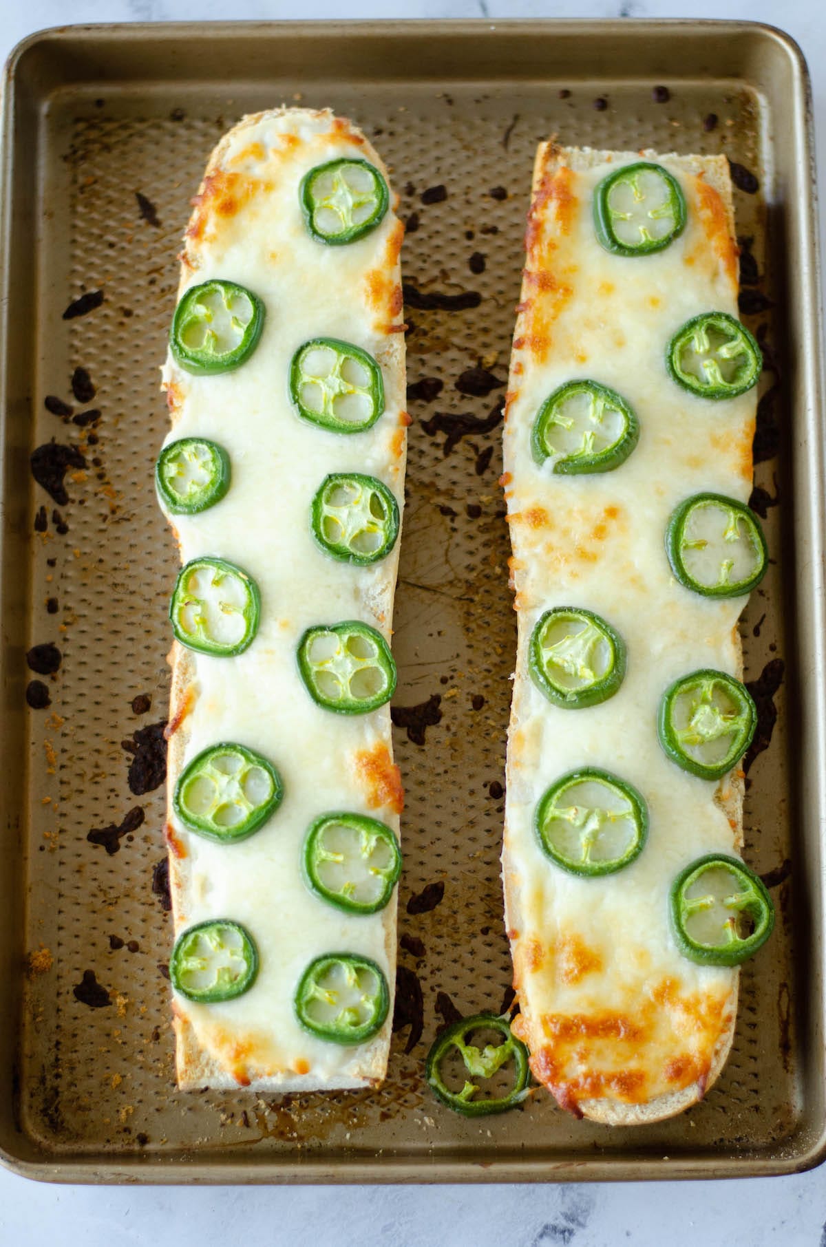 bread with jalapeños on top on a cooking sheet