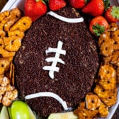 football shaped dip with pretzels, strawberries and apples around the edge
