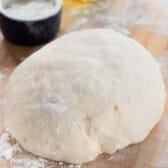 pizza dough rolled up on a cutting board