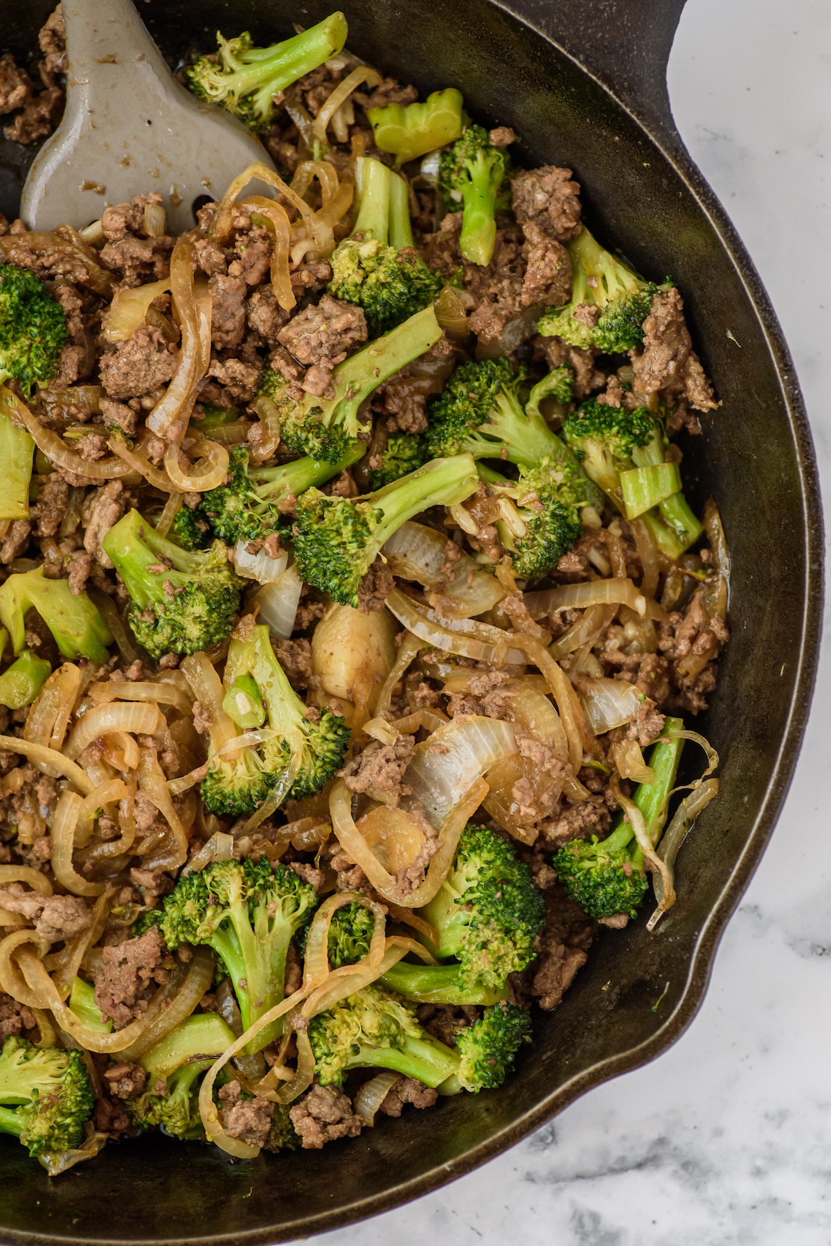 beef, broccoli and other things mixed together in a black pan