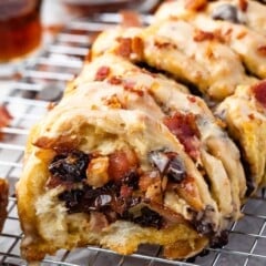 loaf of bacon pull apart bread sitting on a drying wrack with bacon sprinkled on top