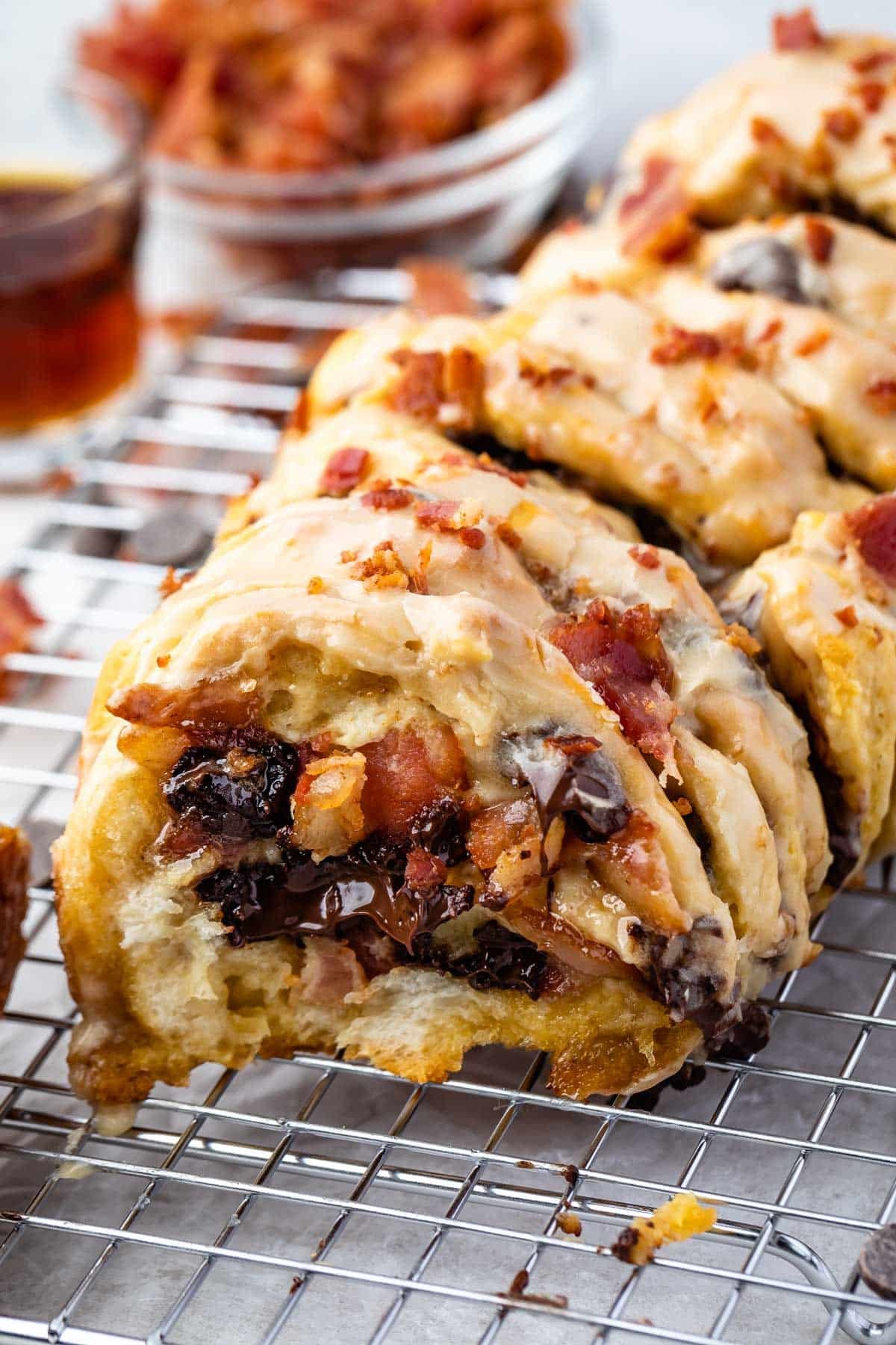 loaf of bacon pull apart bread sitting on a drying wrack with bacon sprinkled on top