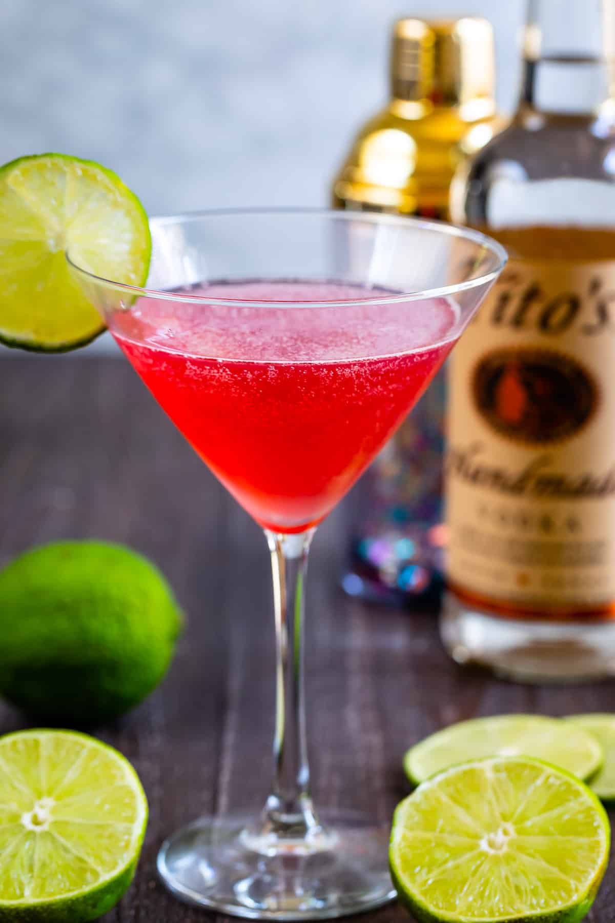 clear cocktail glass with a red drink and lime on the rim