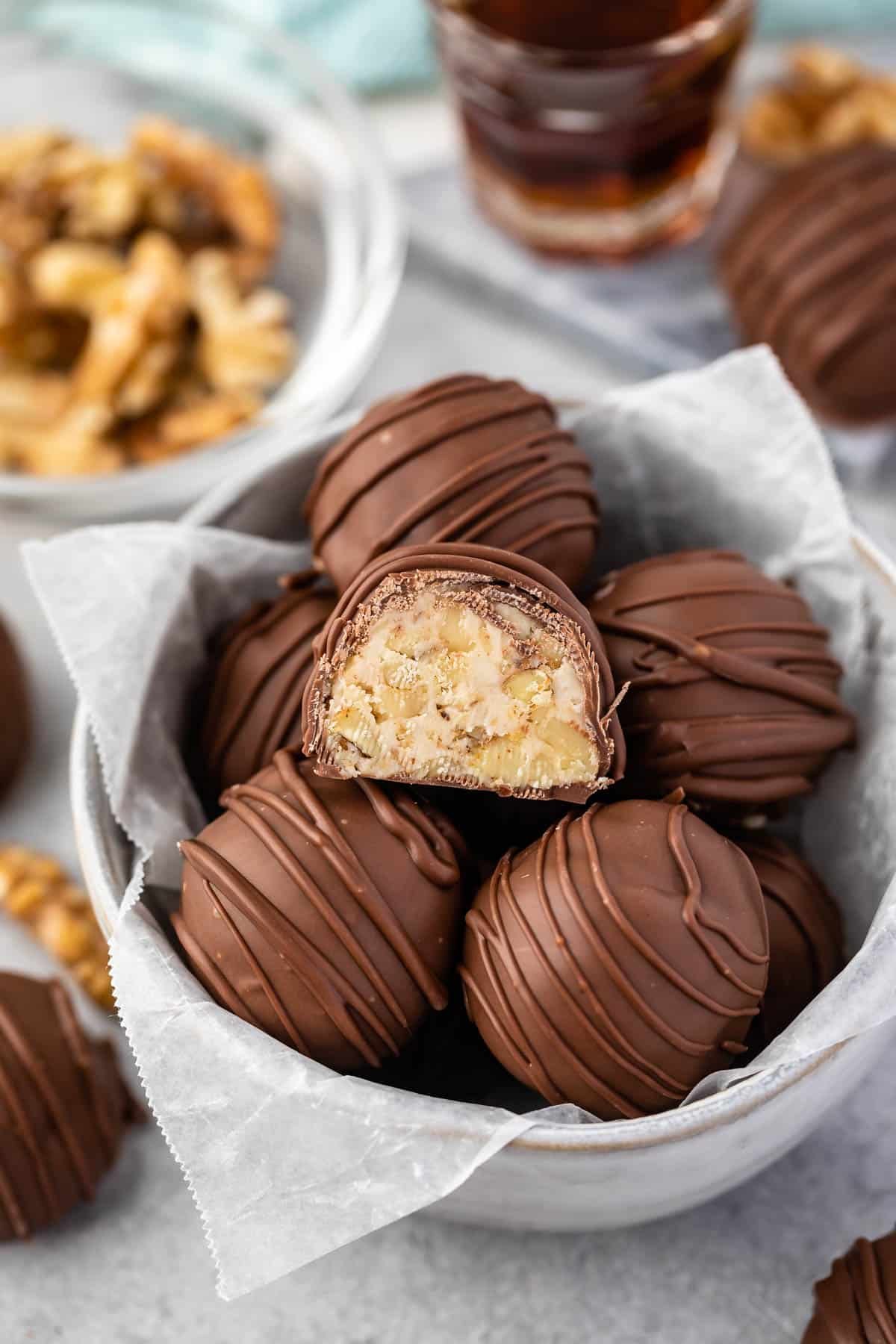 maple walnut truffles covered in chocolate in a white bowl