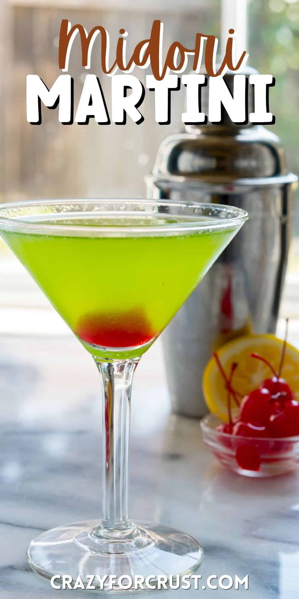 green martini with red at the bottom in a clear glass with words on top