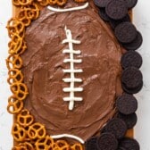 nutella shaped as a football with lines drawn in white surrounded by pretzels and Oreos