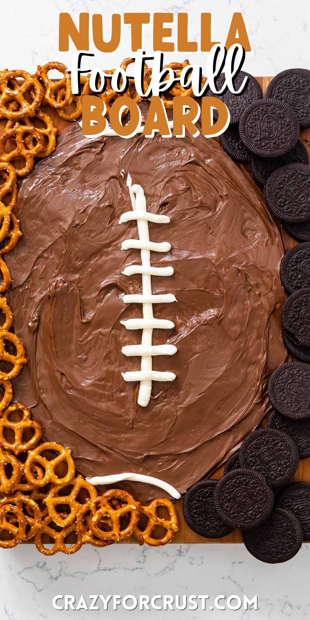 nutella shaped as a football with lines drawn in white surrounded by pretzels and Oreos with words on top