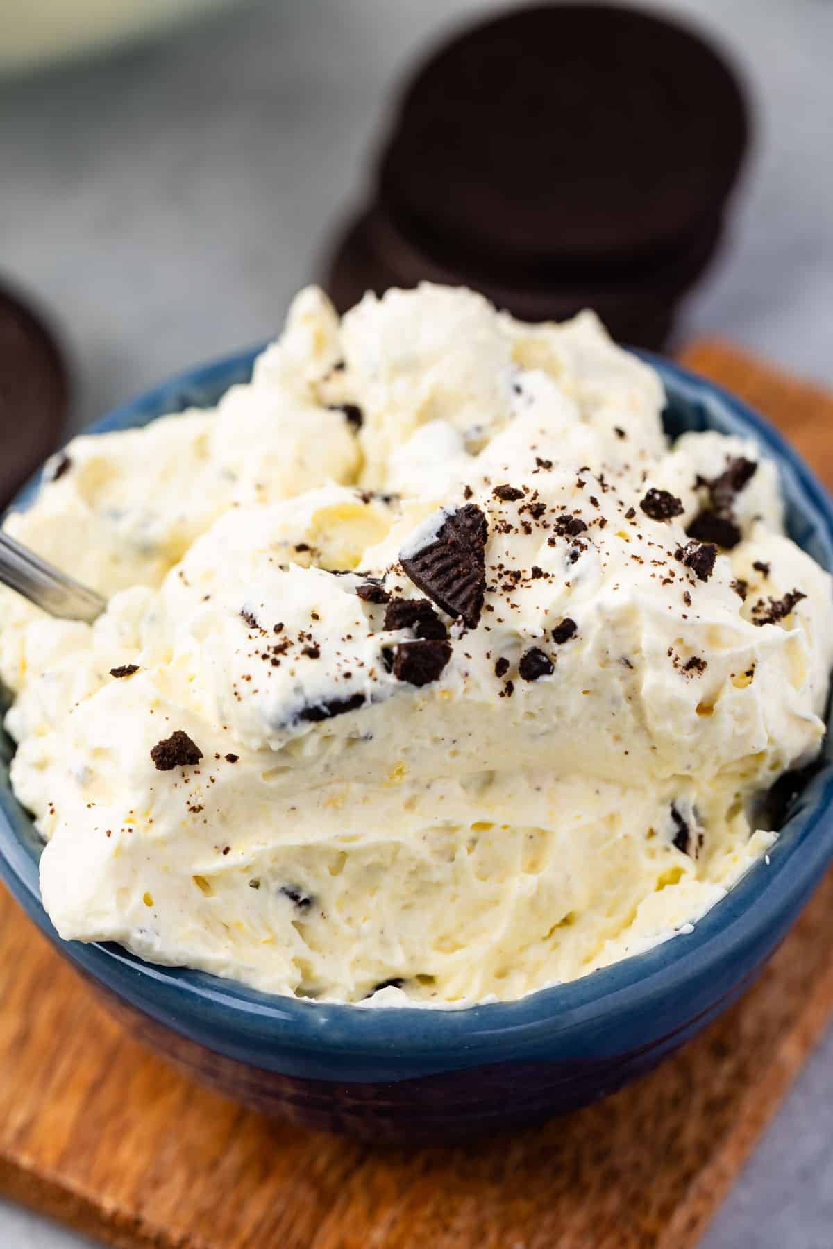 white dip in a blue bowl with Oreos crunched on top