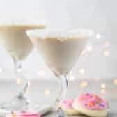 white drink in a a martini glass with sugar cookies around the base of the glass