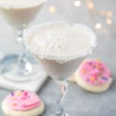 white drink in a a martini glass with sugar cookies around the base of the glass