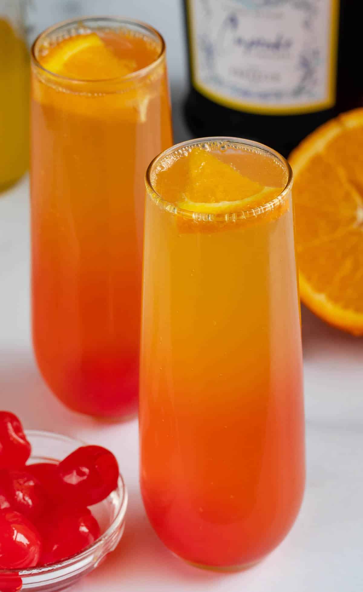 two glasses of orange and red ombre drink inside