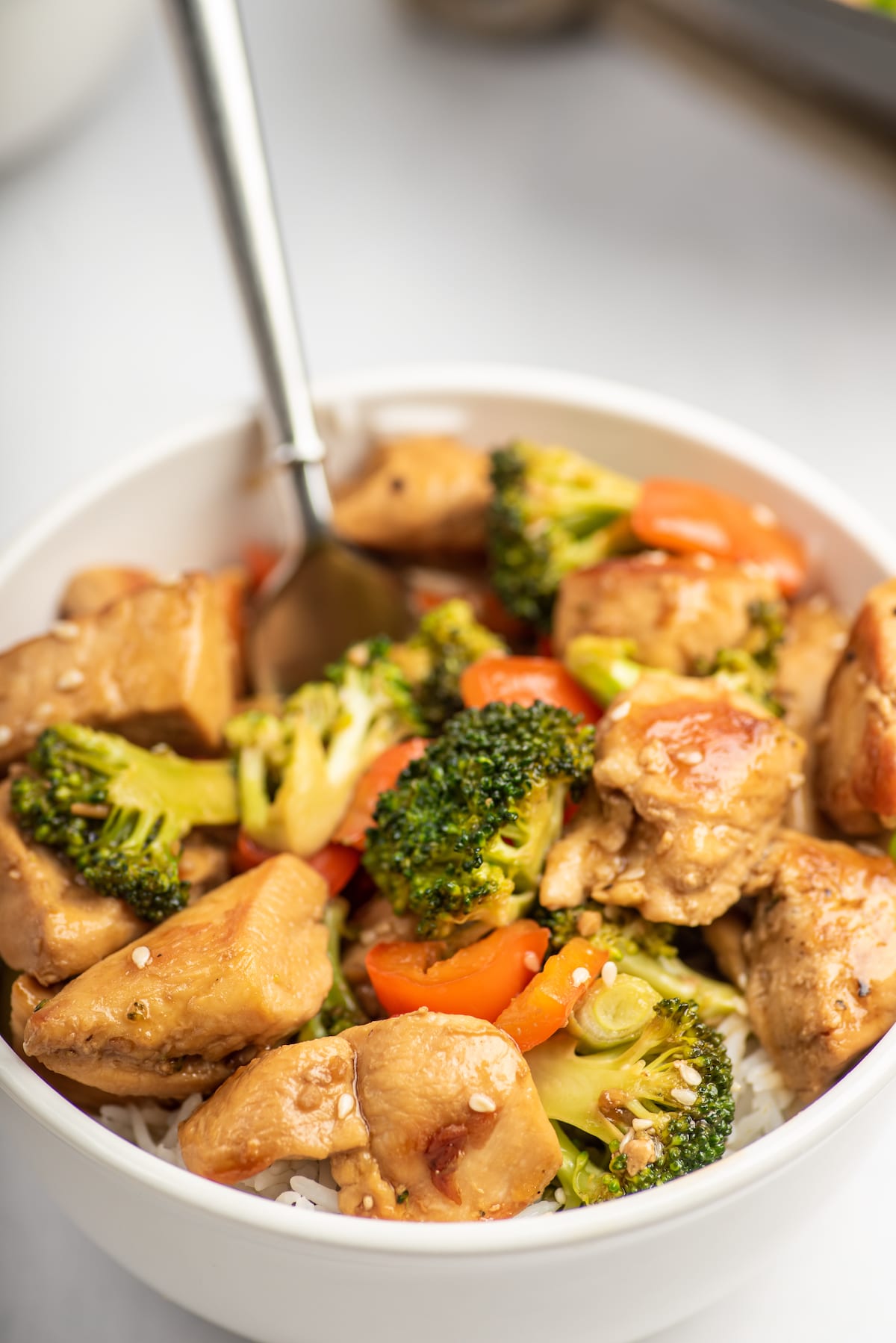 chicken broccoli and carrots in a white bowl