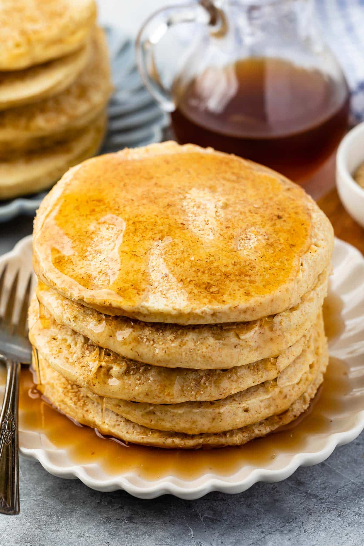 stacked pancakes with syrup poured on top