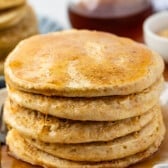 stacked pancakes with syrup poured on top