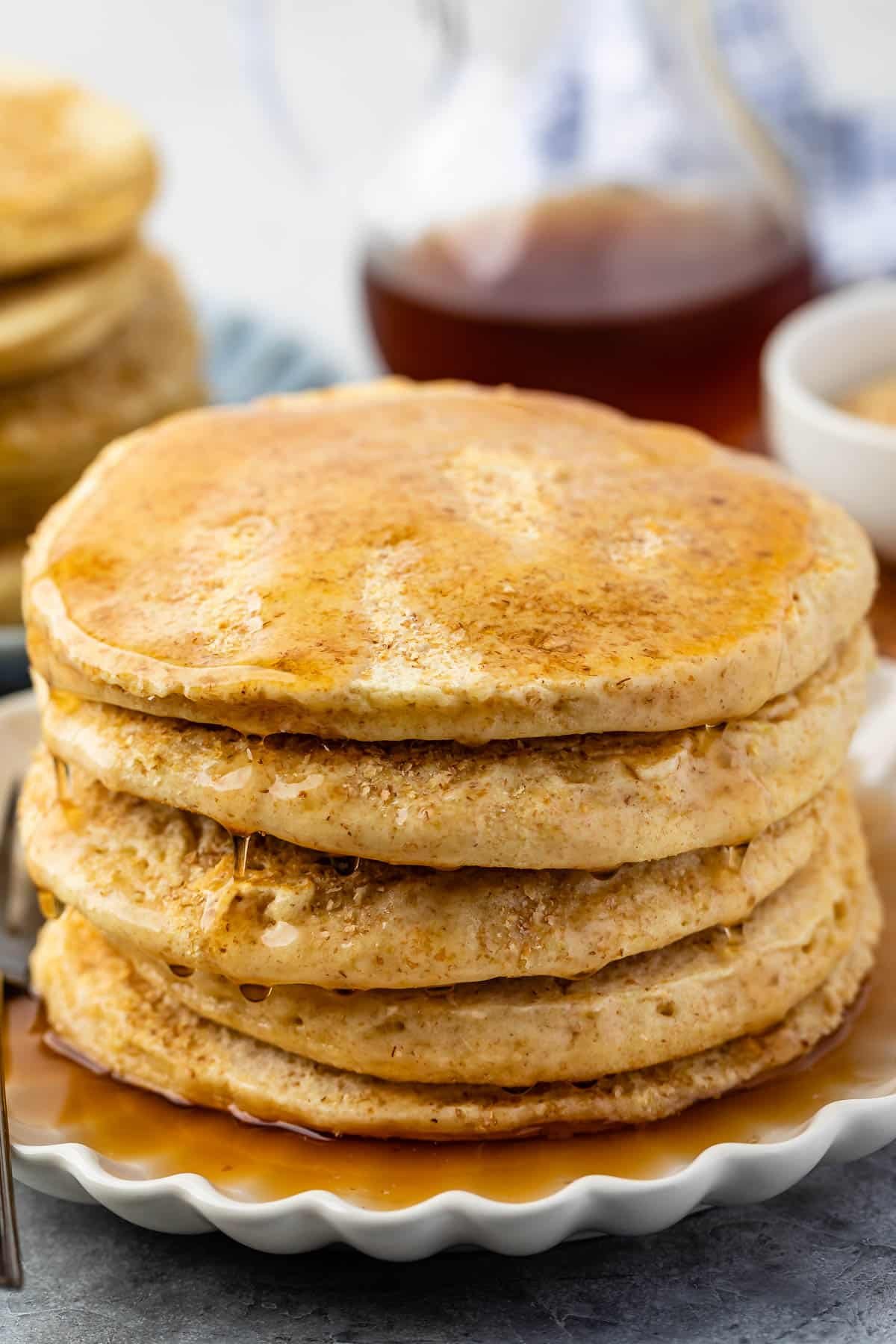 stacked pancakes with syrup poured on top