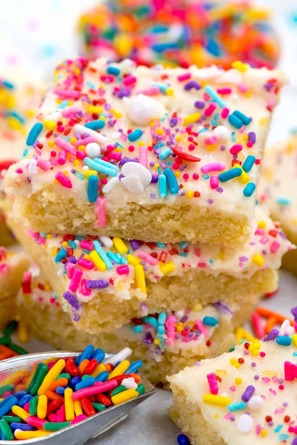 bars with white frosting and colorful sprinkles on top.