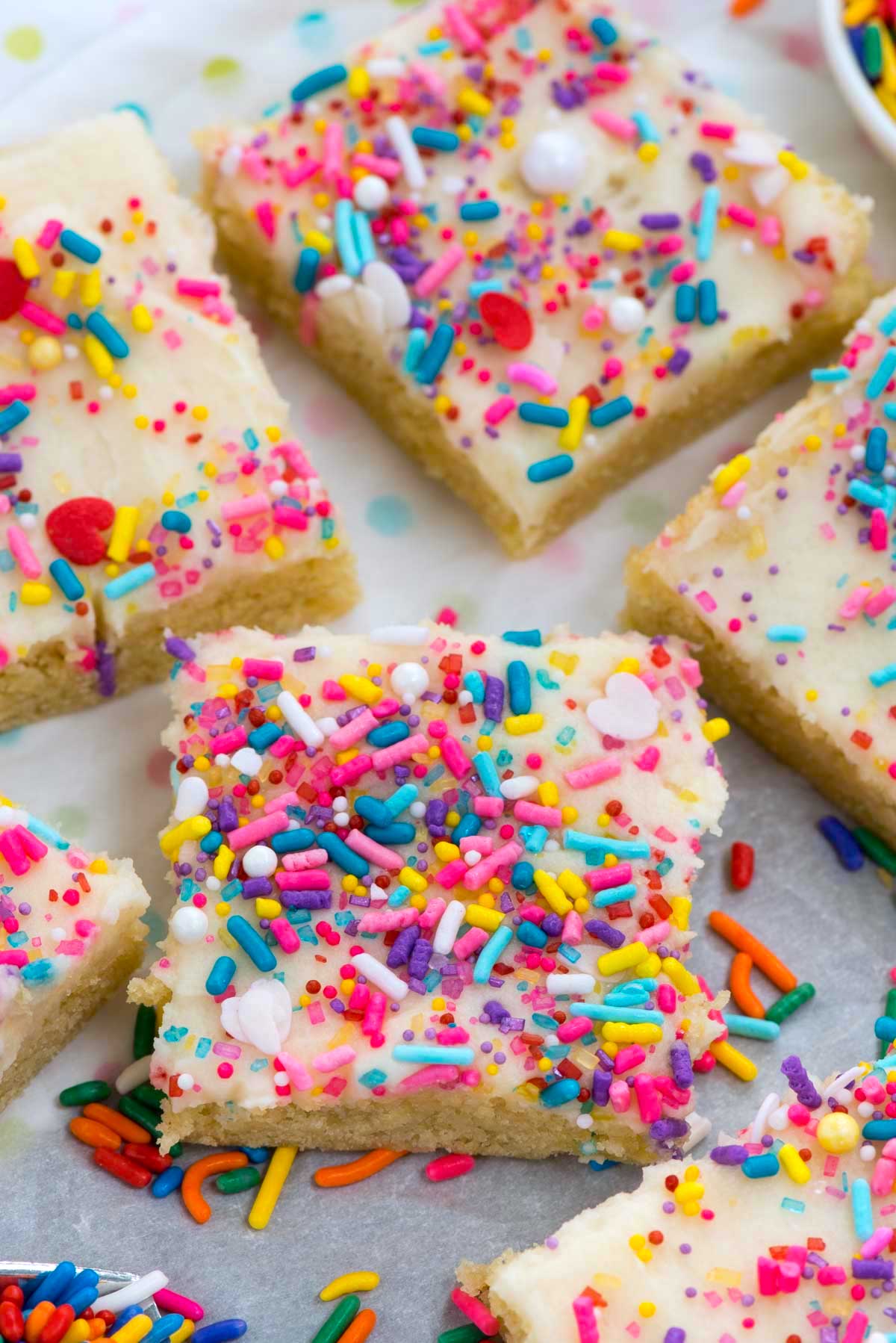 bars with white frosting and colorful sprinkles on top.