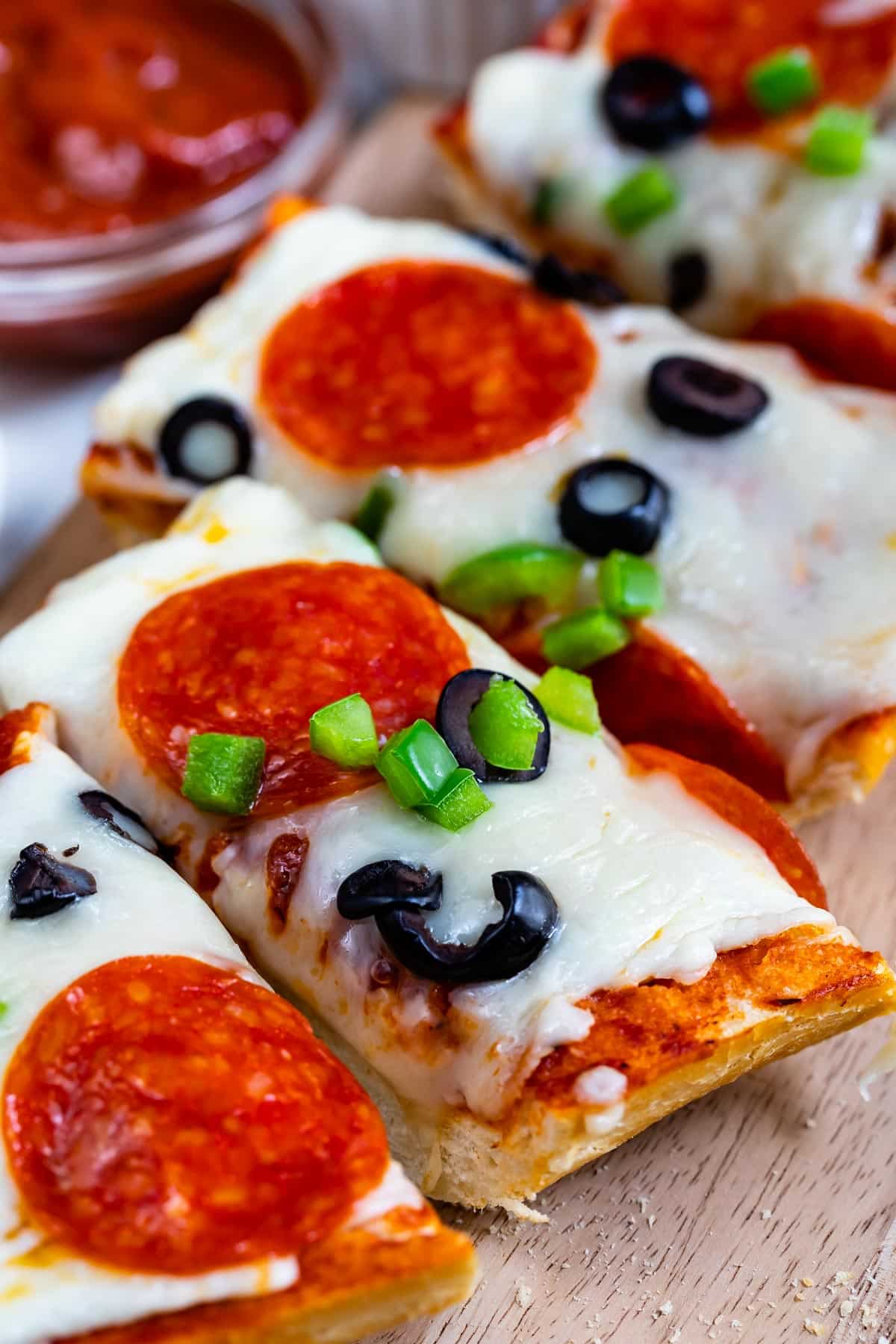 sliced pizza with pepperoni and olives on top