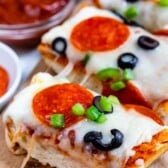 sliced pizza with pepperoni and olives on top