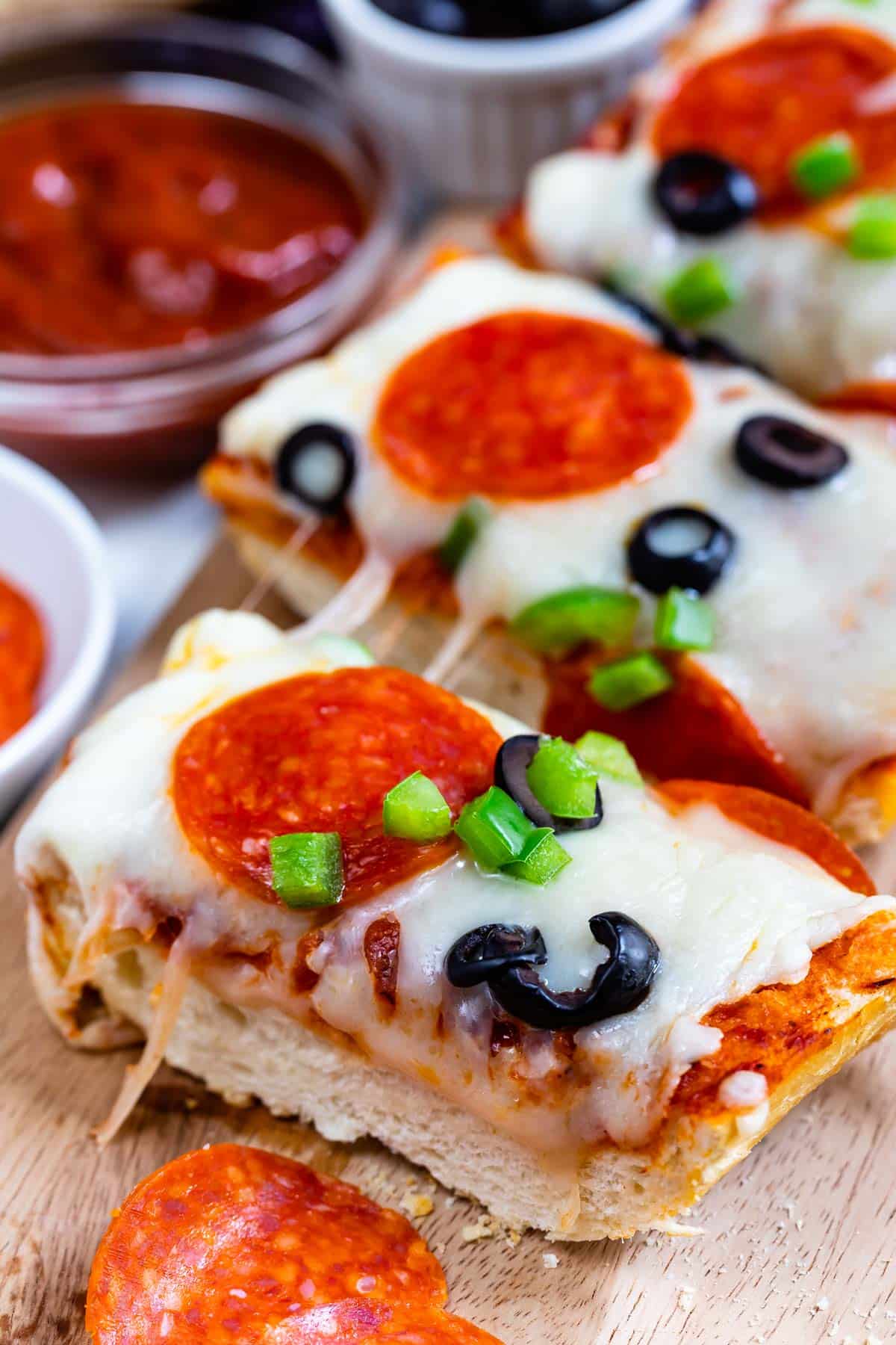 sliced pizza with pepperoni and olives on top