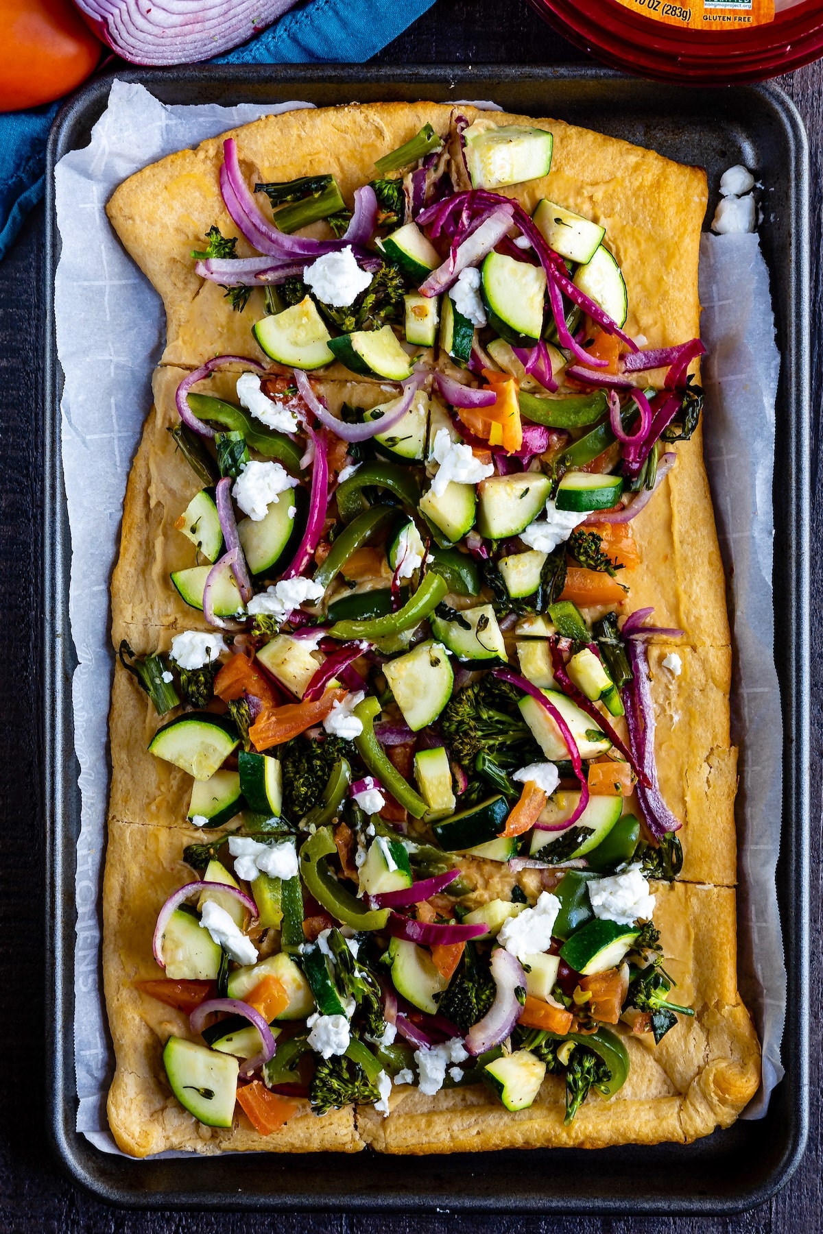 hummus pizza with vegetables on top of the thin crust