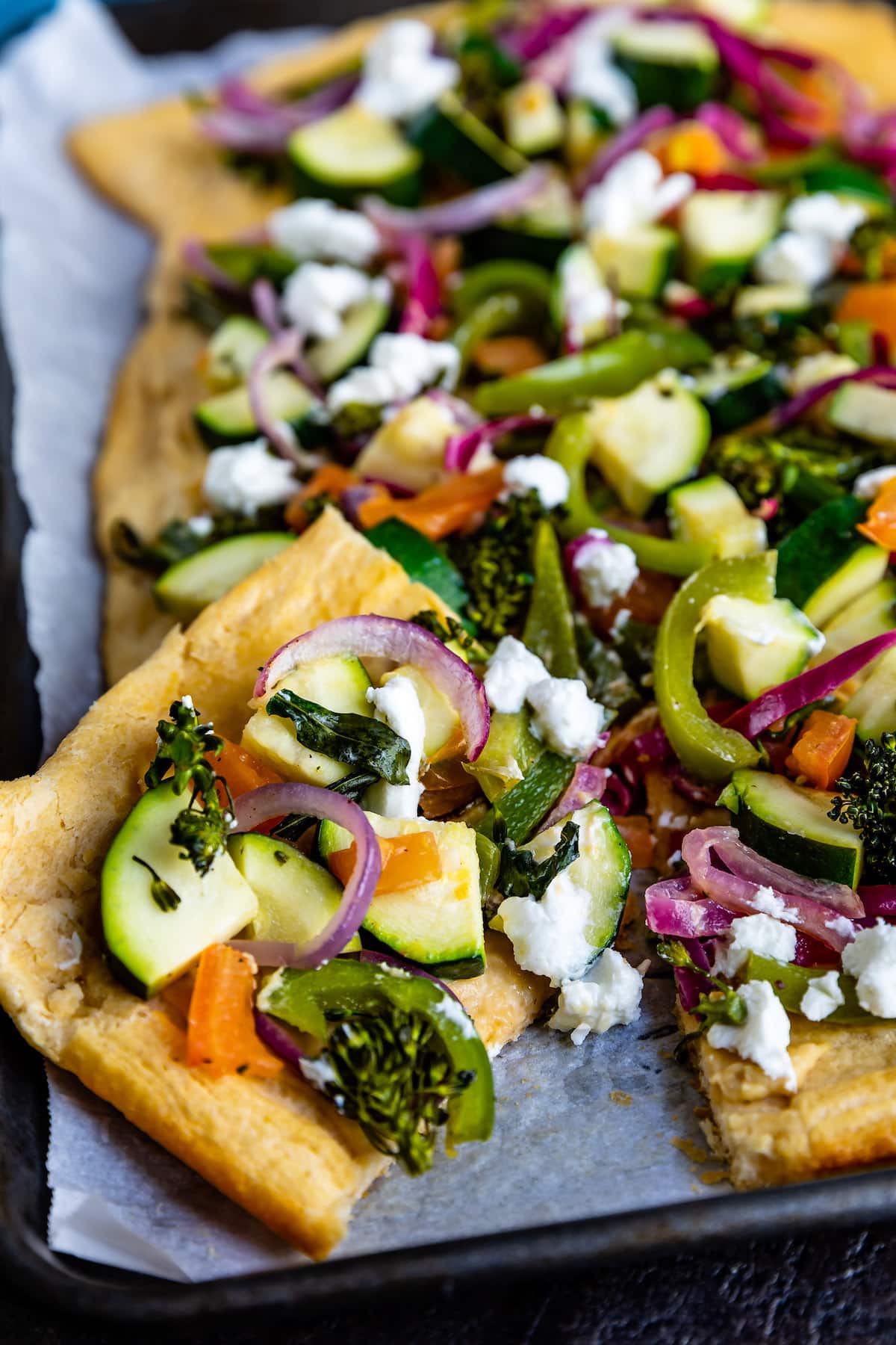 hummus pizza with vegetables on top of the thin crust