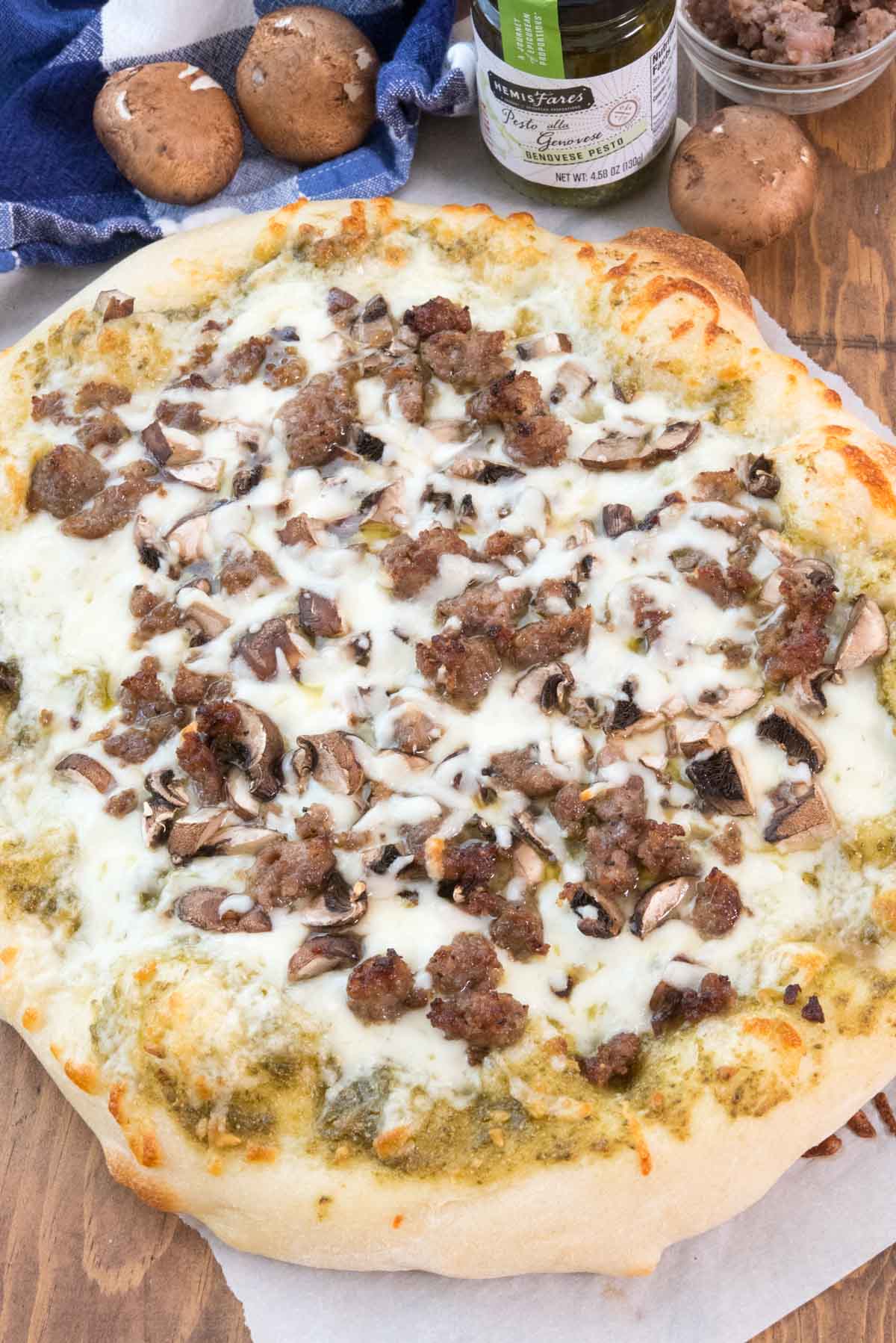 round pizza with sausage and white cheese on top