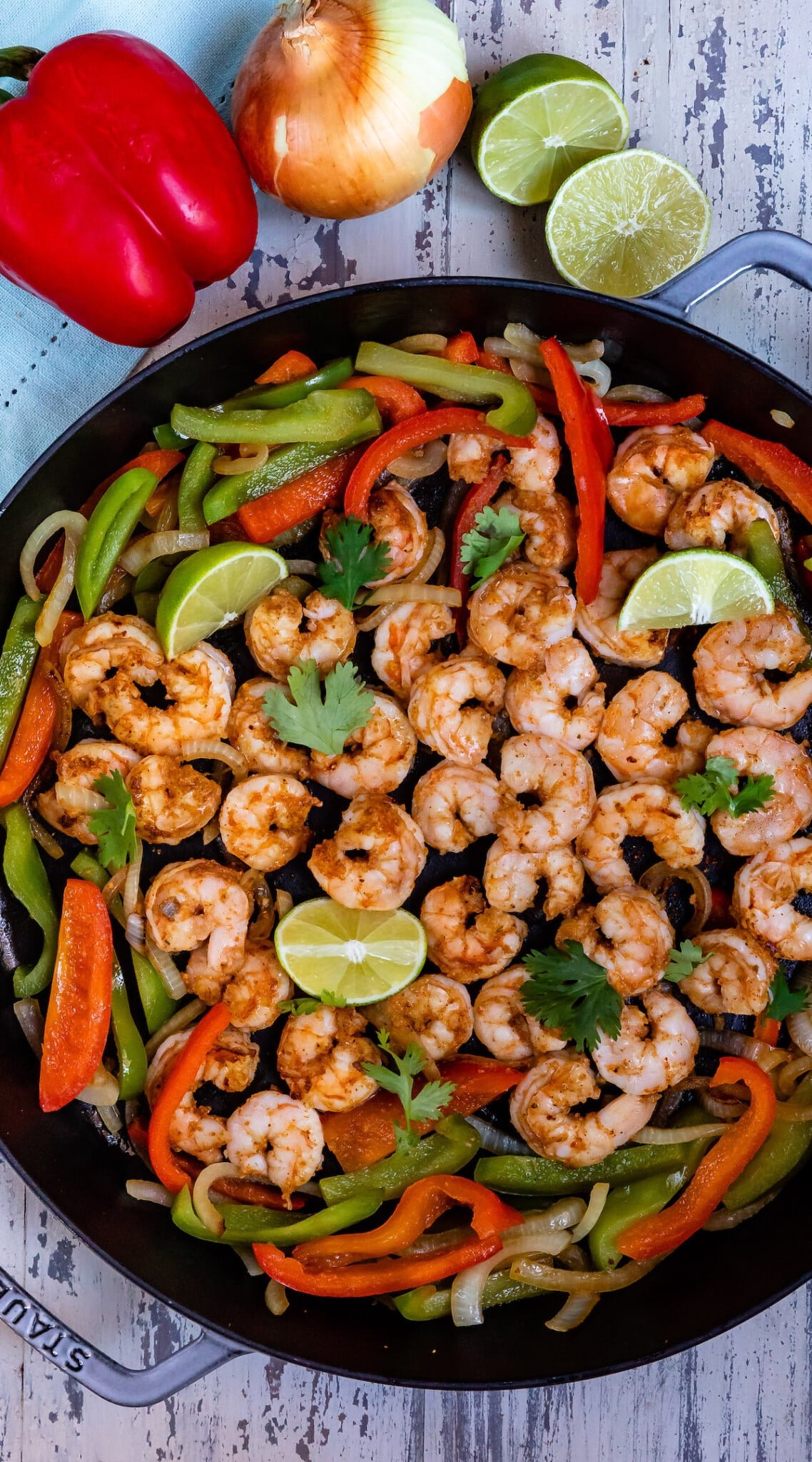 shrimp and limes and peppers mixed together in a black bowl