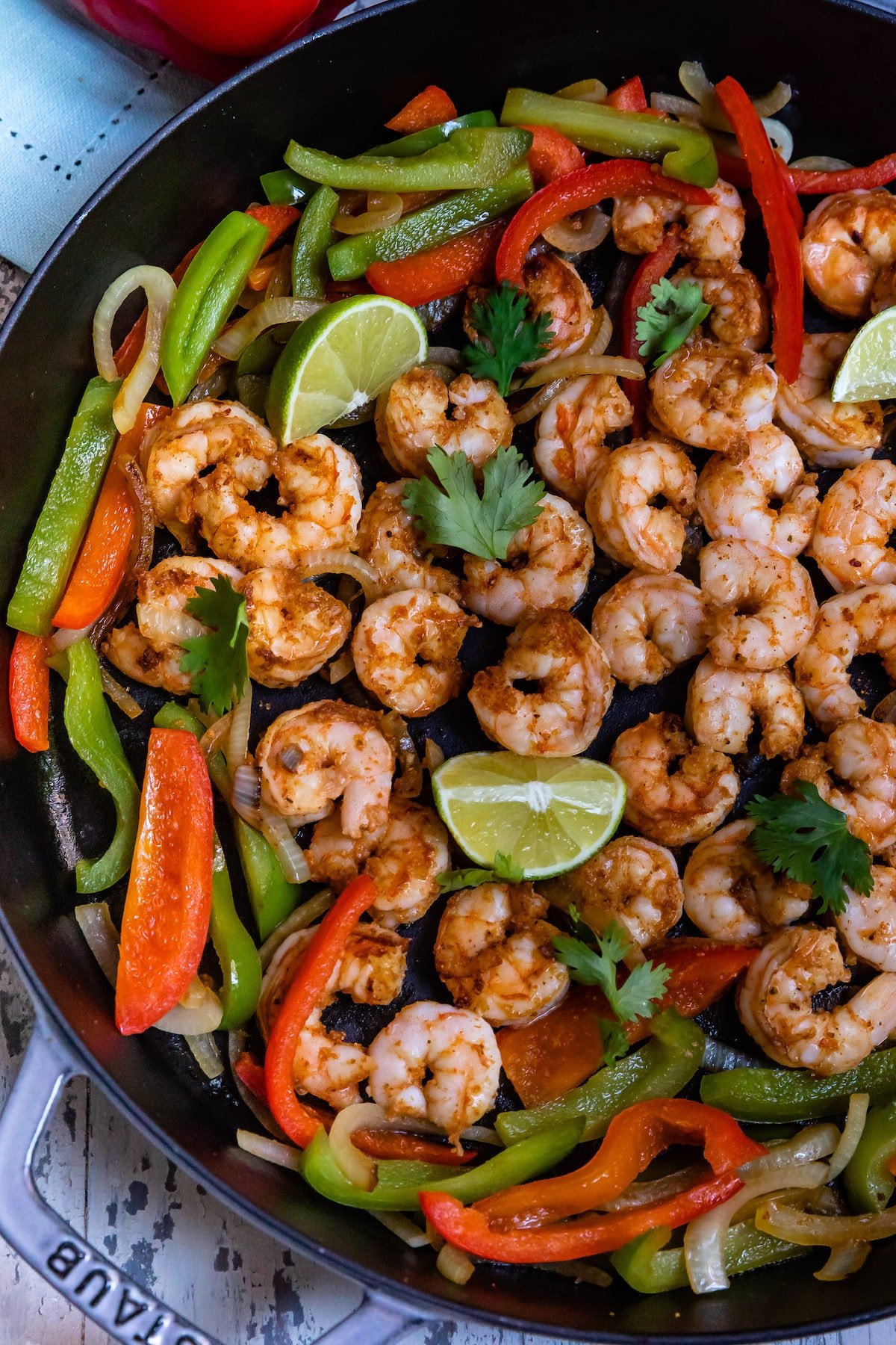 shrimp and limes and peppers mixed together in a black bowl