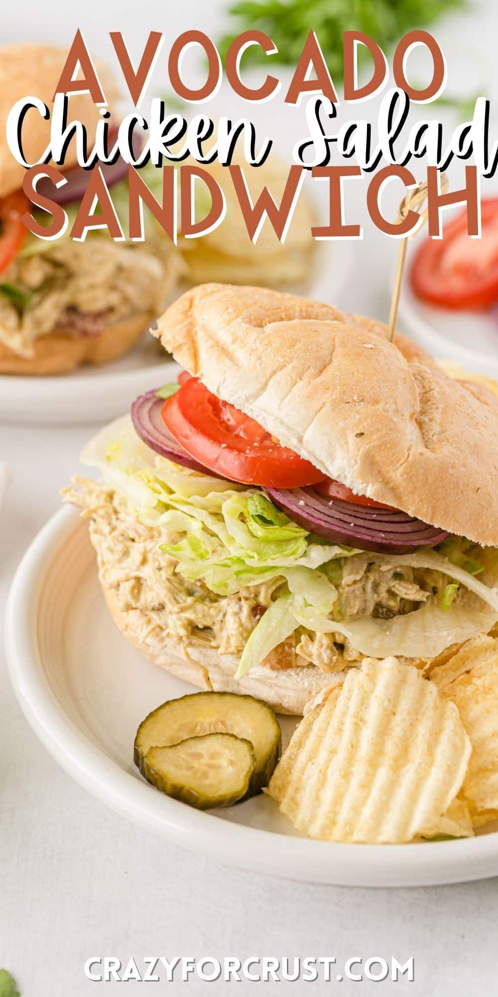 sandwich with lettuce tomatoes and chicken on a white plate with words on the image.