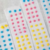 blue, pink and yellow buttons on parchment paper