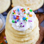 stacked sugar cookies with white icing and sprinkles on top