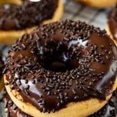 stacked peanut butter donut dipped in chocolate with chocolate sprinkles on top with words on the image