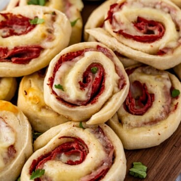 multiple pinwheels laid out on a dark cutting board