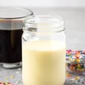 mason jar with creamer inside and sprinkles around the glass