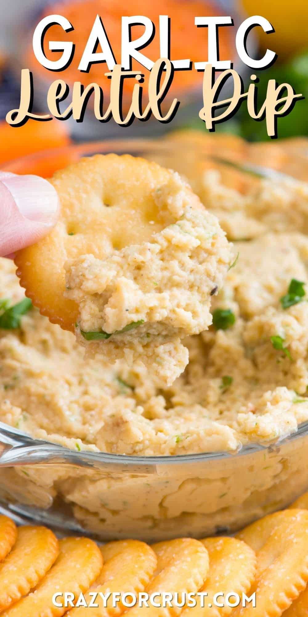 a ritz cracker being dipped in the lentil dip with words on the image