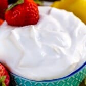 white fluff dip in a teal bowl surrounded by fruit with words on the image