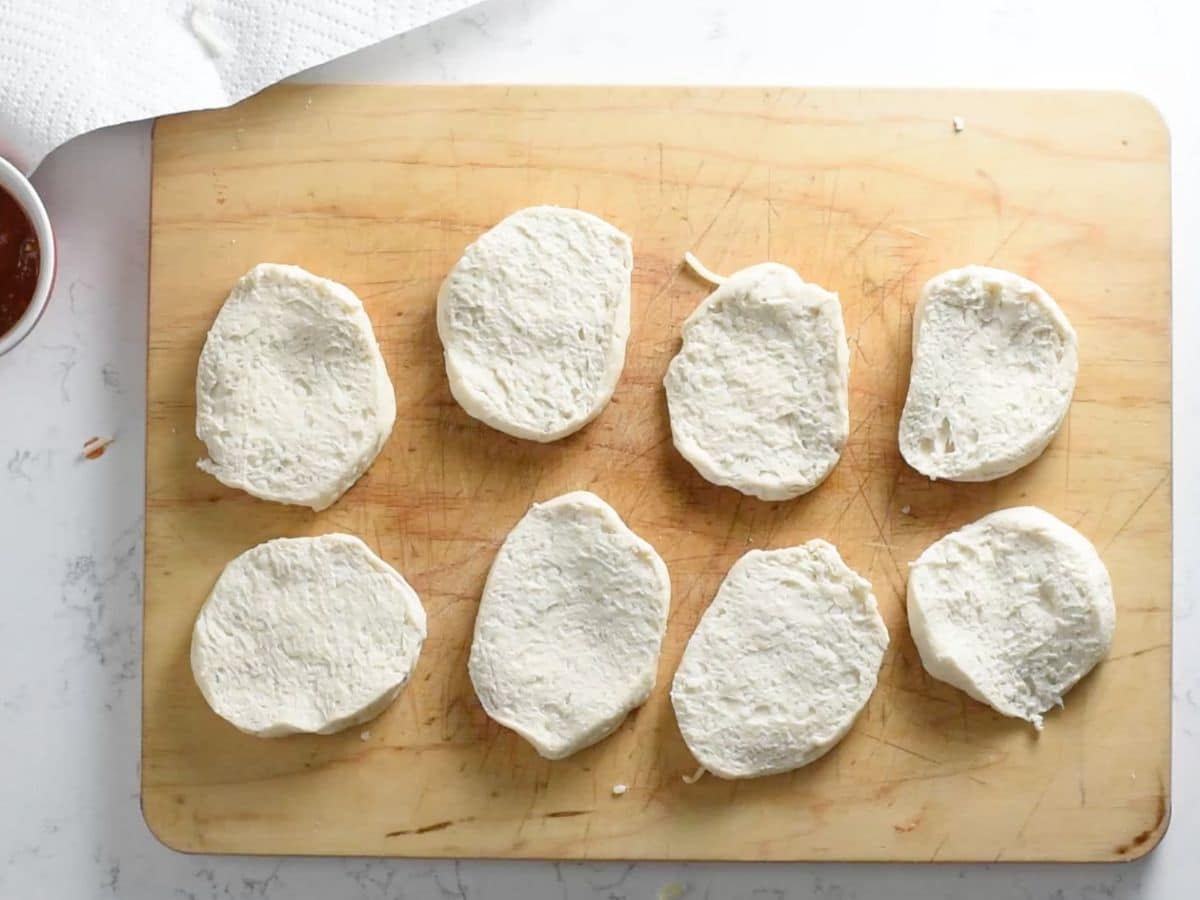 biscuits cut in half on cutting board.