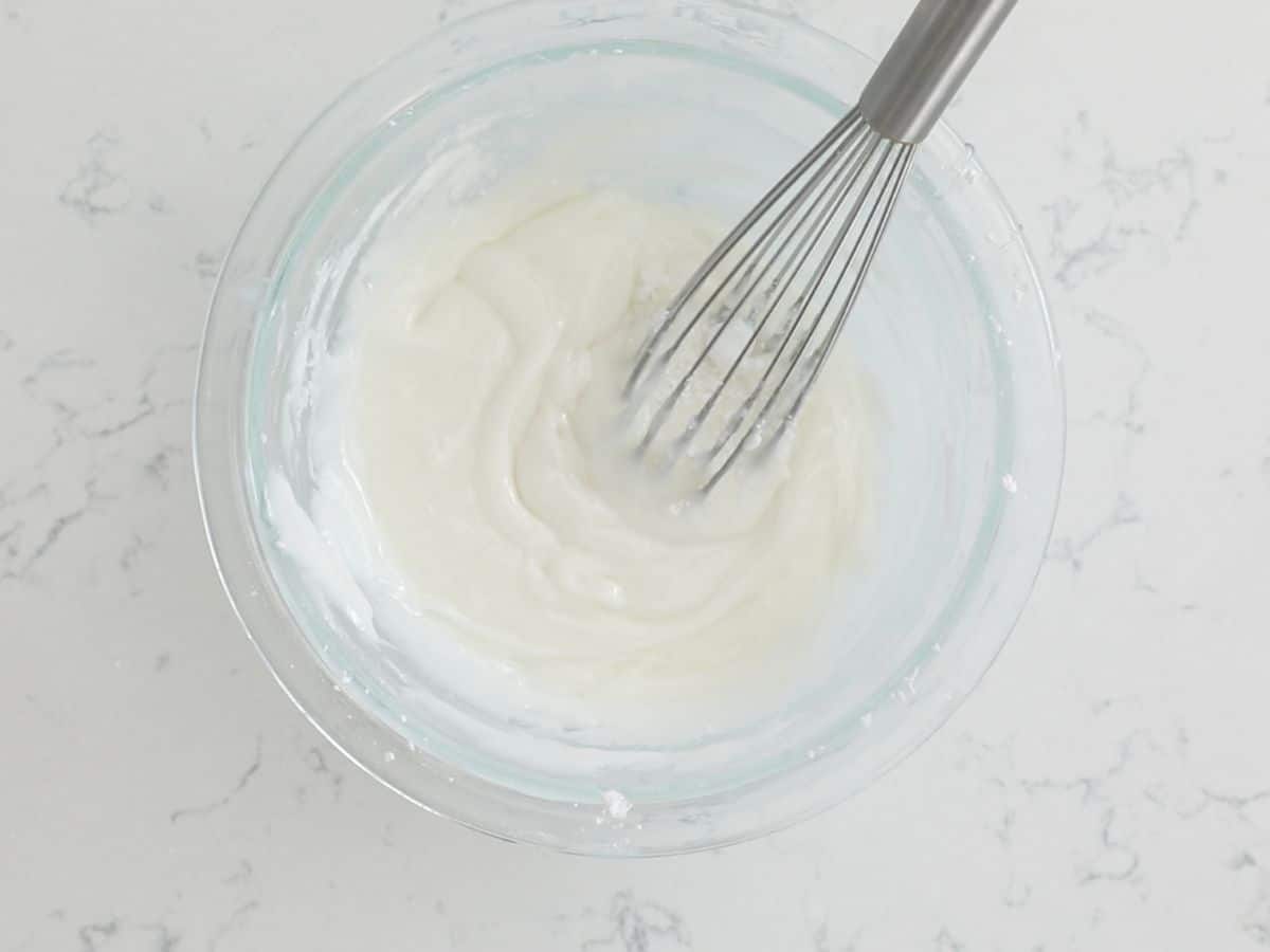 bowl of icing with whisk.