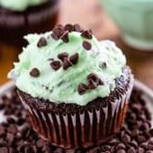 chocolate cupcakes with green mint frosting on top and in the center of the cupcake.