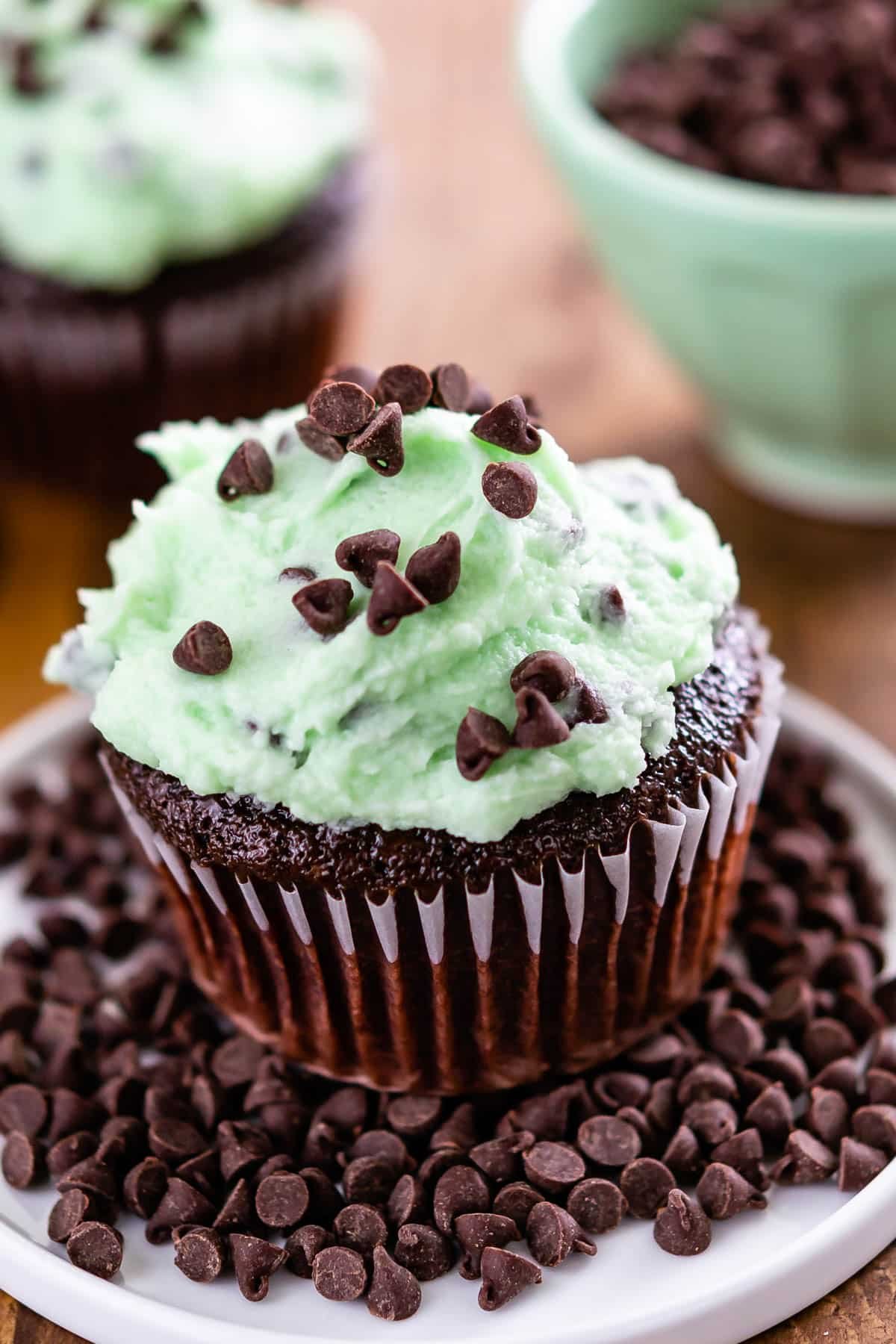 chocolate cupcakes with green mint frosting on top and in the center of the cupcake.