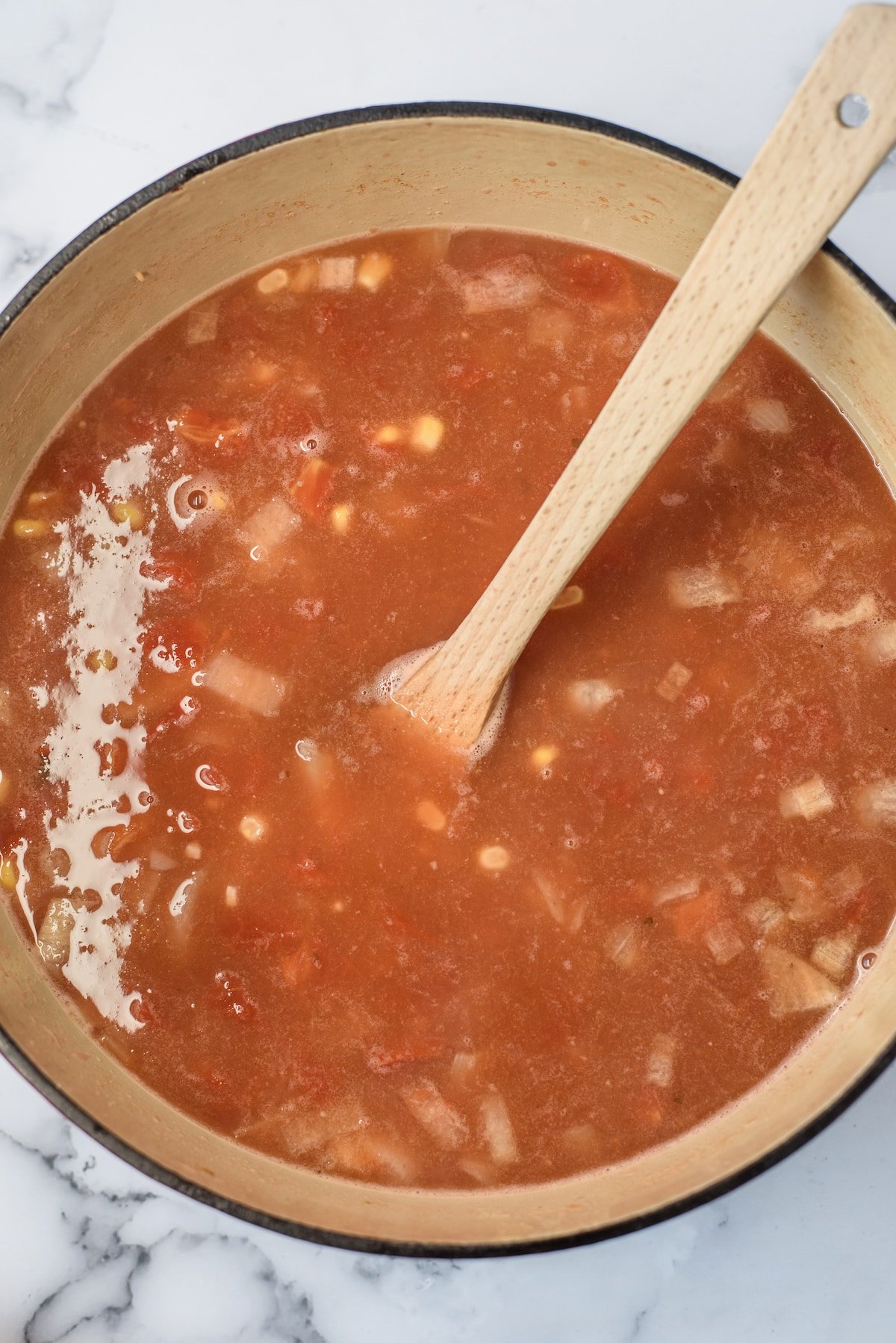 soup in pot and wooden spoon